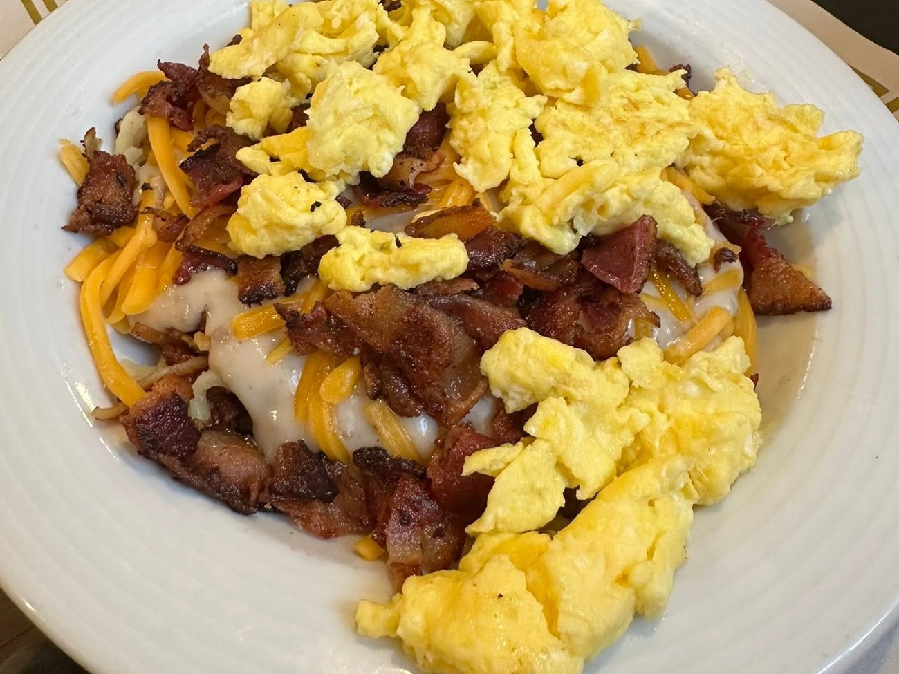 Breakfast bowl with scrambled eggs, bacon, cheddar and hashbrowns, with toast