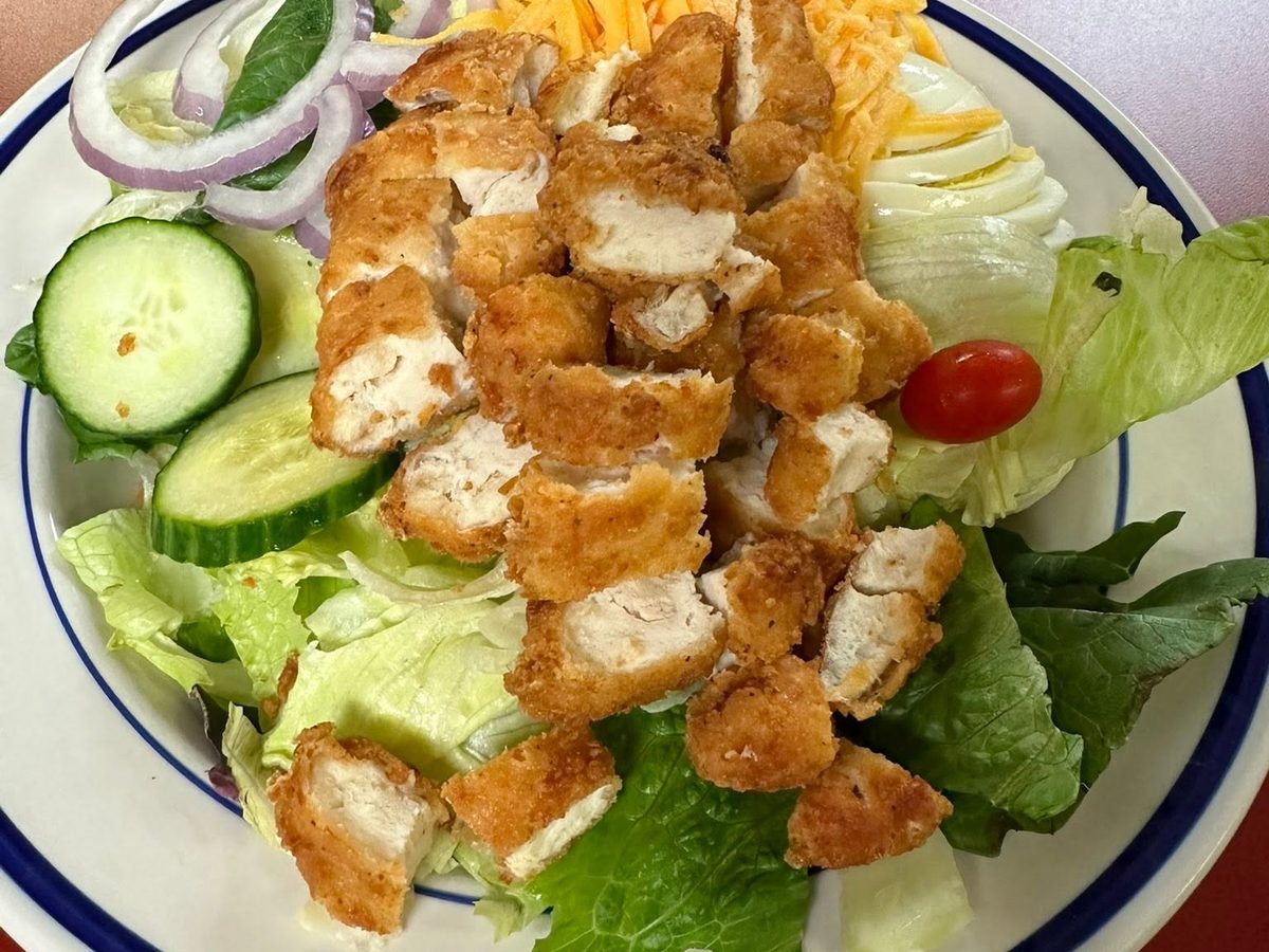 Breaded chicken over garden salad with cheddar