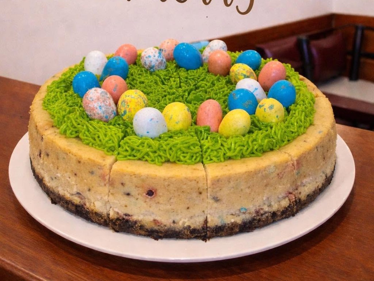 Easter cheesecake with candy eggs and green buttercream grass