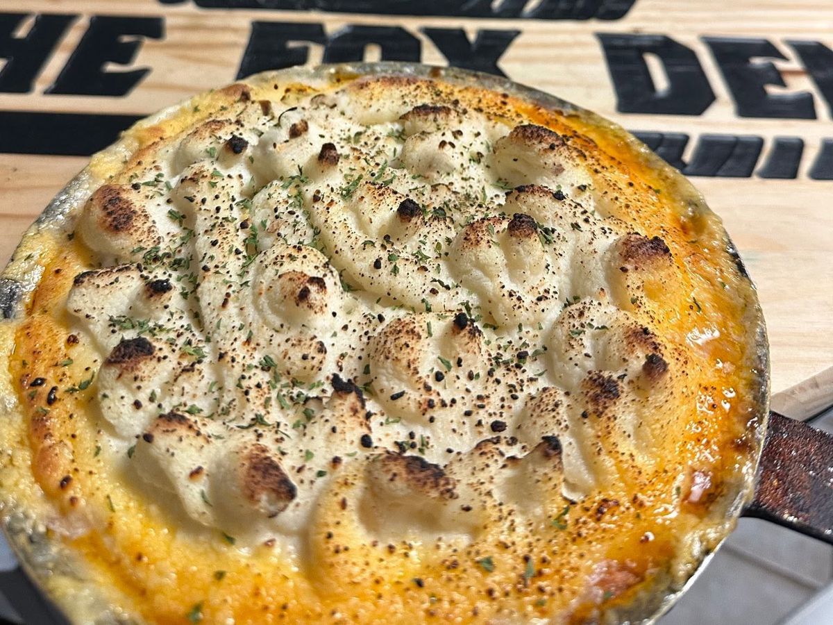 Shepherd's pie in a cast iron skillet with a browned mashed potato topping