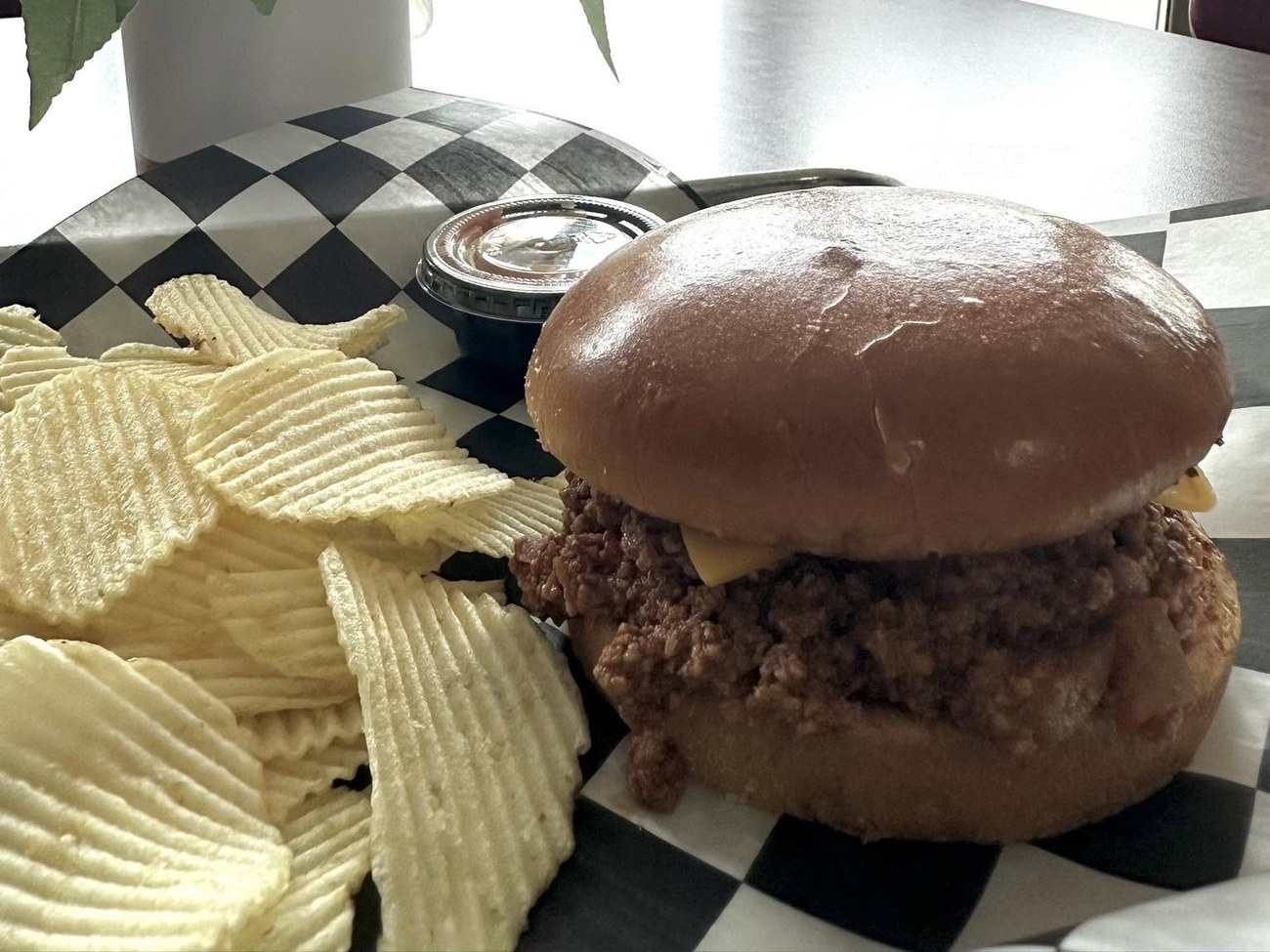 Sloppy joe on a brioche bun with potato chips