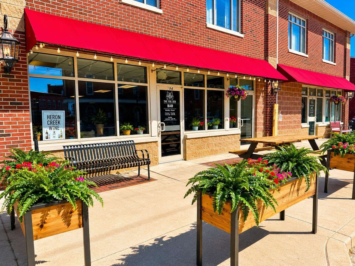 Patio picnic table and fern planters outside the bar