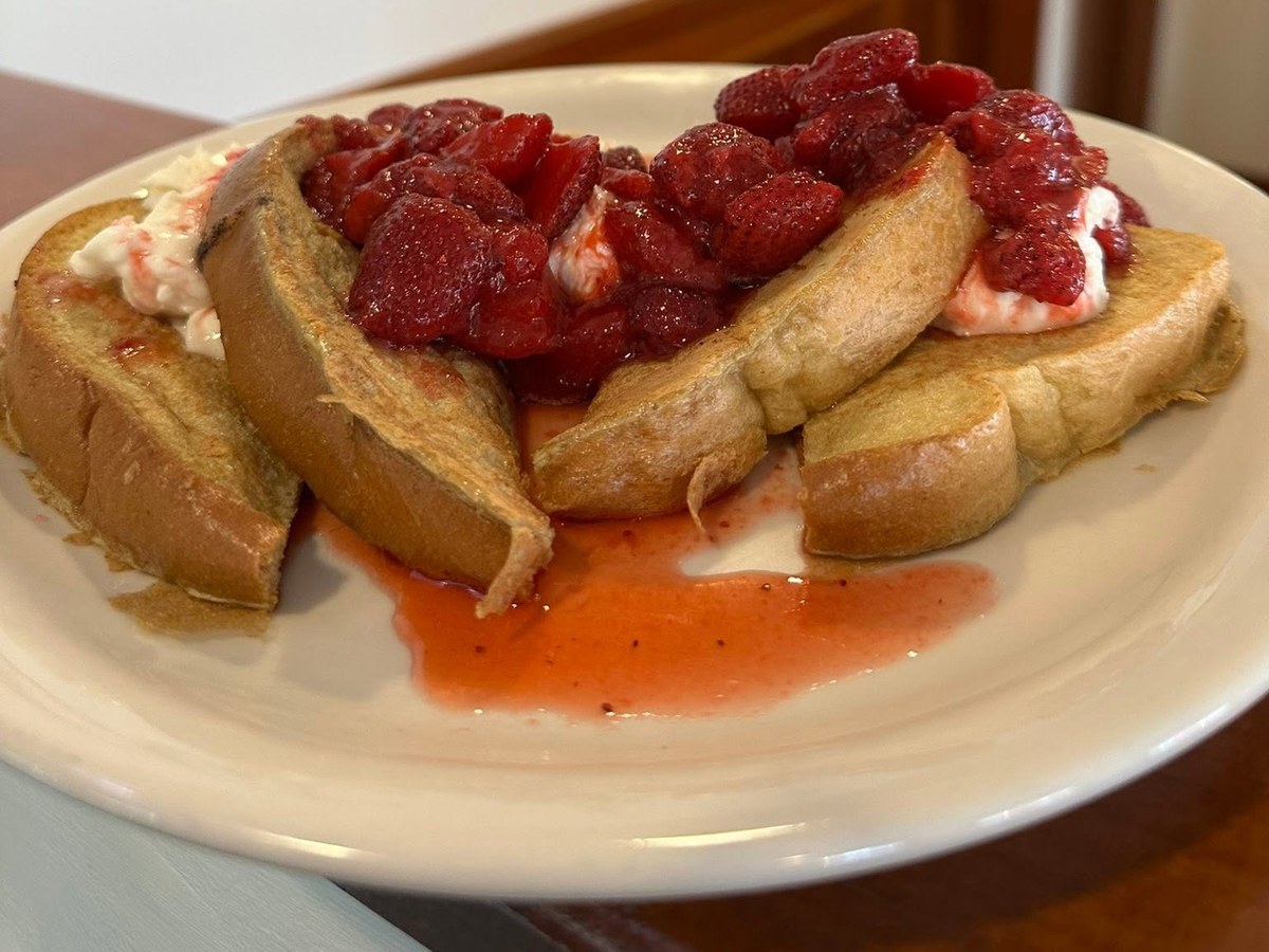 Thick-cut French toast topped with strawberries and whipped cream